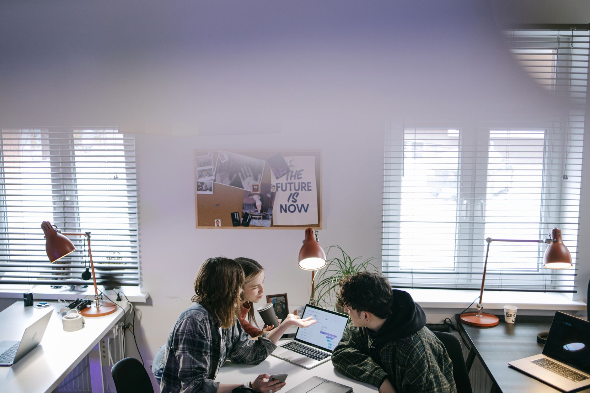 A group of people discussing ideas around laptops in a bright, modern office space — illustrating: Tampa IT Consulting Firms Ranked by Cost and Service Quality: A Central Florida Business Owner's Guide